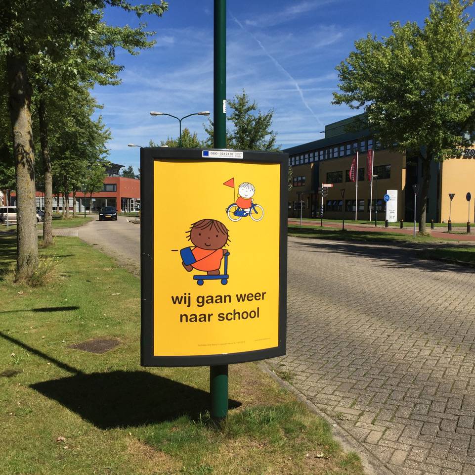 Campagne wij gaan weer naar school dick bruna nijntje posters op straat aan begin van schooljaar start opletten op kinderen die fietsen en lopen naar school verkeersveiligheid rondom scholen in schoolzones voorkomen ongelukken fietsende kleuters peuters