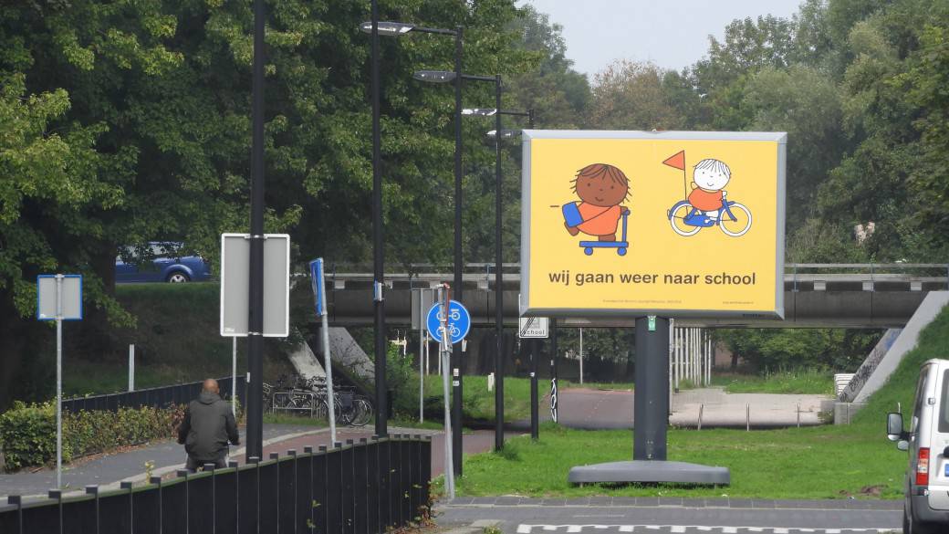 Campagne wij gaan weer naar school dick bruna nijntje posters op straat aan begin van schooljaar start opletten op kinderen die fietsen en lopen naar school verkeersveiligheid rondom scholen in schoolzones voorkomen ongelukken fietsende kleuters peuters