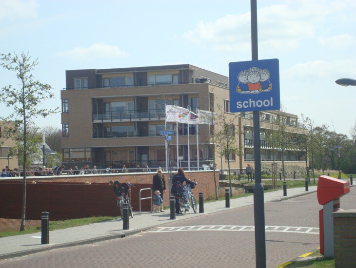 Attentiebord Dick Bruna 'school'. Verkeersbord attendeert weggebruikers op schoolgaande kinderen.